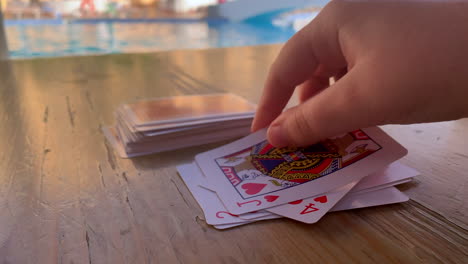 Playing-cards-next-to-a-swimming-pool-on-holiday-vacation-in-the-sun