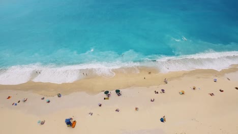 Drone-panning-from-the-right-to-the-left-side-of-the-frame-above-the-beach-of-Myryos,-a-popular-destination-in-the-island-of-Kefalonia,-Greece