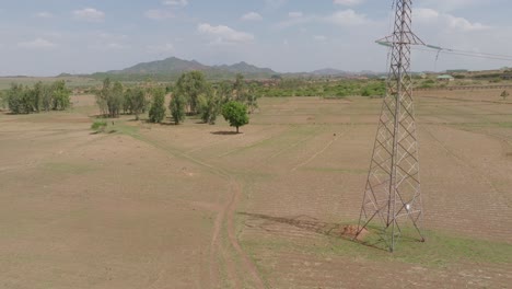 Aerial---Descending-shot-of-vast-landscape-by-massive-power-line-in-Nigeria