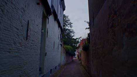 European-small-and-narrow-street-with-houses-in-the-evening,-cinematic-walkthrough-walking-walk