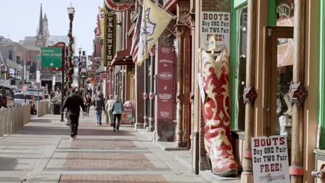 Tourists-on-Broadway-Street-in-Nashville,-Tennessee-during-the-day-with-close-shot-video-pan-right-to-left