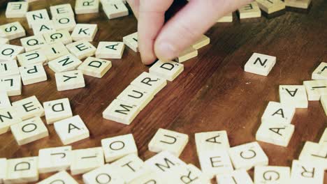 Letras-Brillantes-De-Mosaicos-De-Scrabble-Se-Voltean-Para-Formar-La-Palabra-Asesinato-En-La-Mesa