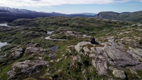 Aerial-shot,-over-a-series-of-small-lakes,-surrounded-by-a-rocky,-moss-covered-landscape-in-Norway