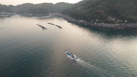 Sunrise-landscape-of-Japanese-Kyotango-Beach-Travel-Aerial-Drone-Japan-Travel-destination,-boathouses-at-natural-environment-Top-Down-View-above-follow-boat