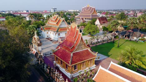 Traditional-arched-roof-pagoda-in-Laoation-city,-Savannakhet,-drone-aerial-rotate-during