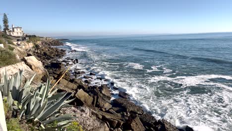 Strand-Von-Cascais-Mit-Kieselsteinen-An-Der-Küste,-Die-Von-Meereswellen-Umspült-Werden