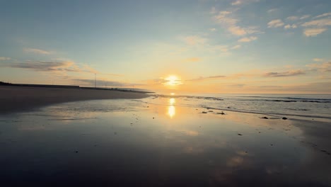 A-tranquil-scene-captures-waves-crashing-onto-the-shore,-with-sunset-hued-clouds-on-the-horizon,-embodying-the-untouched-beauty-of-nature's-evening-embrace