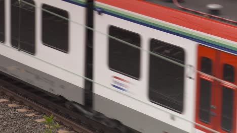 Train-speeding-on-tracks,-capturing-the-essence-of-modern-travel-and-transportation,-daylight