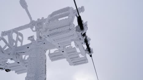 POV-ride-on-chairlift-passing-frozen-supporting-tower-in-Skrzyczne,-Poland