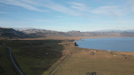 Pueblo-Tranquilo-Junto-Al-Fiordo,-Camino-Sinuoso-Y-Nubes-Tenues,-Verano-En-Islandia