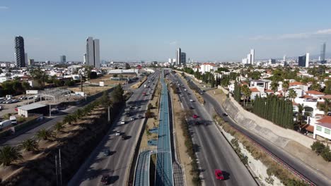 Slow-forward-flight-above-Mexican-highway-with-traffic-in-Puebla-City