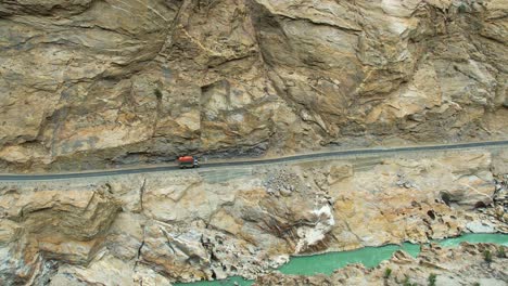 Aerial-shot-of-a-vehicle-driving-though-JSR-road-in-Skardu,-Pakistan