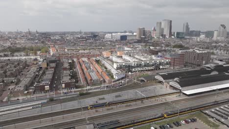 Tilt-up-droneshot-of-The-Hague-HS-railway-station-while-train-is-arriving