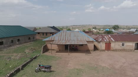 Aerial---Sideway-drone-of-unpainted-weathered-houses-in-rural-Nigerian-village