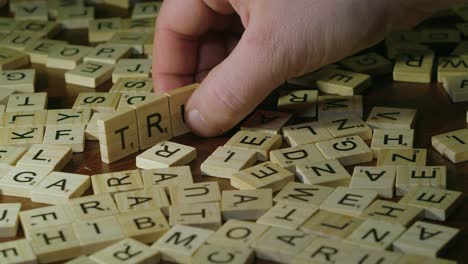 Las-Letras-De-Azulejos-De-Scrabble-De-Primer-Plano-Forman-La-Palabra-Verdad-Con-La-Mano-Derecha-Del-Hombre