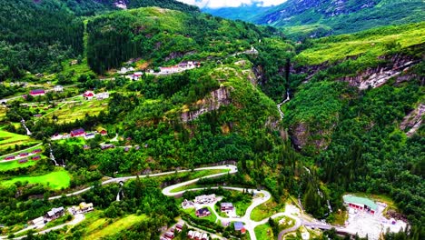 Luftaufnahme-Des-Dorfes-Geiranger,-Panoramastraße-Und-Grüne-Landschaft-über-Dem-Fjord,-Norwegen