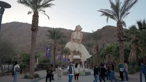 Marilyn-Monroe-statue-in-Palms-Springs,-California-with-tourists-and-video-stable-wide-shot