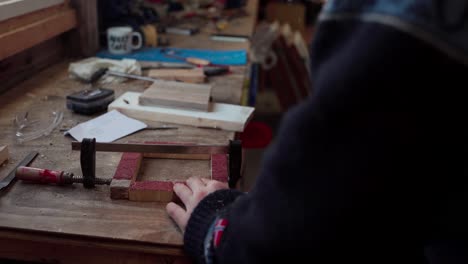 Hombre-Atornillando-Las-Esquinas-De-La-Caja-De-Madera-Segura-Con-Una-Abrazadera