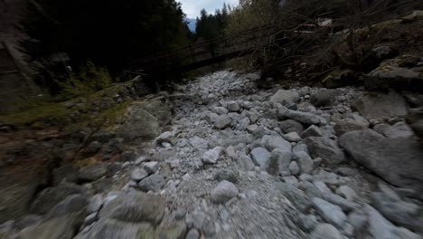 Luftbild-FPV-Verfolgt-Eine-Andere-Drohne-über-Felsen-Und-Bäume-Im-Val-Masino,-Italien