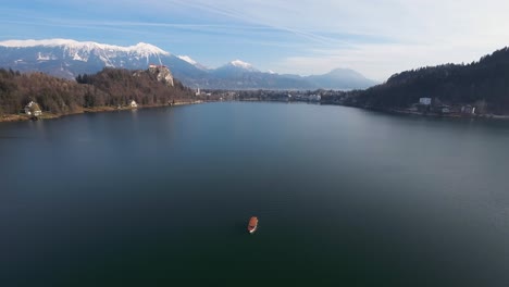 Barco-Navegando-Por-El-Lago-Bled-Con-Los-Alpes-Al-Fondo