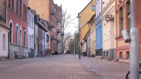 Low-trucking-reveal-shot-of-bicycles-parked-on-empty-brick-street,-Gamla-staden