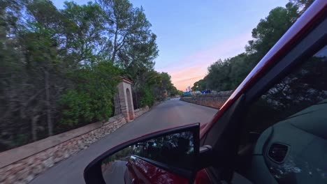 POV-From-Left-Wing-Mirror-Of-Car-Driving-Along-Road-During-Golden-Hour-In-Palma-de-Mallorca