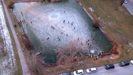 Group-Of-People-Skating-On-Frozen-Lake---Aerial-Drone-Shot