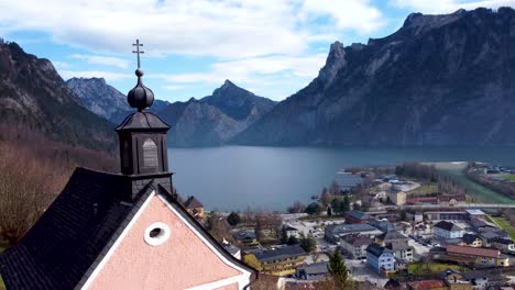 Church-spire-overlooking-Traunsee-lake-and-Ebensee-town-in-the-Salzkammergut-region,-Upper-Austria,-serene-mountain-backdrop