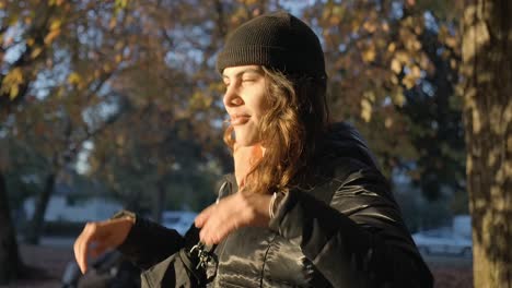 Retrato-De-Una-Mujer-Con-Sombrero-Negro-Y-Chaqueta-De-Cuero-En-Un-Parque-Durante-La-Puesta-De-Sol