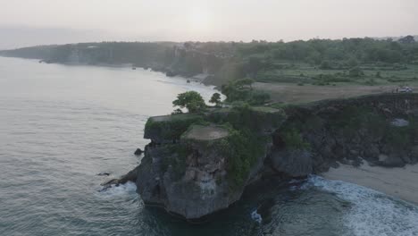 Aerial-drone-flying-over-tropical-Balangan-Beach-peninsula-at-sunrise-in-Uluwatu-Bali-Indonesia