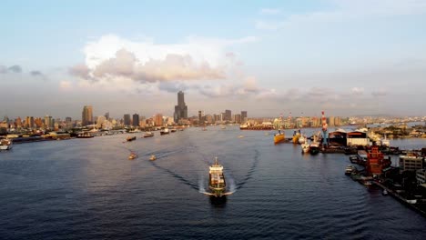 A-bustling-port-with-ships-and-cranes-during-golden-hour,-aerial-view