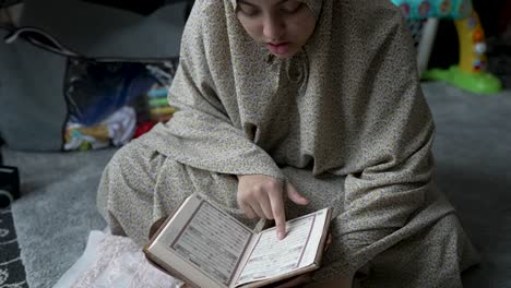 Young-Muslim-Woman-Reading-Quran-At-Home---Close-Up