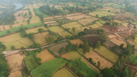Complex-mosaic-of-Agriculture-Fields-across-rural-India-with-a-road-and-a-distant-river,-rural-landscape