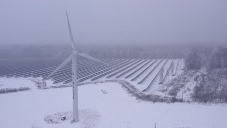 Primer-Plano-De-Un-Drone-Sobre-Un-Aerogenerador-Tikupoiss-En-Un-Clima-Helado-Y-Nevado-Que-Produce-Electricidad