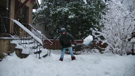 A-man-clears-the-driveway-to-a-house-from-snow-with-a-shovel