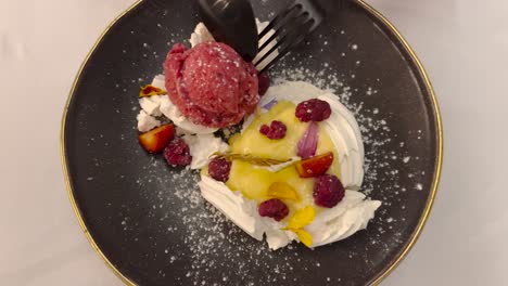 A-sweet-dessert-with-ice-cream-and-fresh-fruit-eaten-with-cutlery