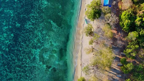 Vertical-top-down-drone-footage-of-bamboo-houses-on-the-beach-near-Palawan-in-the-Philippines