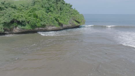 Low-altitude-aerial-drone-shot-over-polluted-muddy-sewage-water-and-floating-trash-with-debris-over-dead-coral-reef-mixing-with-turquoise-water-and-tropical-coastine-in-Bali-Indonesia