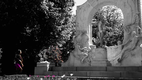Beautiful-Asian-woman-in-purle-clothes-visiting-Johann-Strauss-monument-in-black-and-white-coloring,-slowmotion,-wide-shot