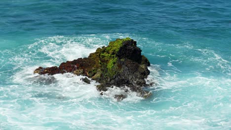 Olas-Turbulentas-Rompiendo-Contra-Roca-Volcánica-De-Basalto,-Clima-Soleado-En-Un-Caluroso-Día-De-Verano-En-El-Centro-Turístico