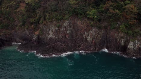 Panoramic-Cliff-forest-rock-aerial-drone-above-blue-sea-waves-crushing-Japanese-beach-at-Kyotango-Kyoto-Kansai,-landscape,-Asian-travel-destination