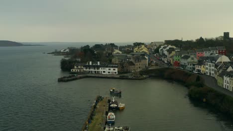 Toma-Aérea-Dinámica-Sobrevolando-El-Puerto-De-Roundstone-Y-La-Calle-Principal,-Connemara.