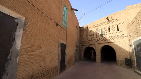 Schmale-Gasse-In-Sbeitla-Mit-Traditioneller-Backsteinarchitektur,-Blauer-Himmel