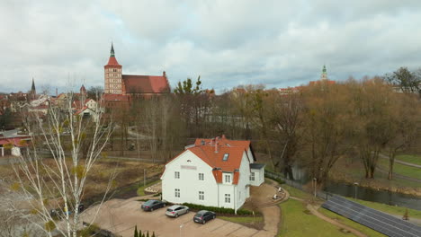 Weißes-Haus-In-Der-Nähe-Einer-Burg-Und-Kahlen-Bäumen-In-Olsztyn,-Polen