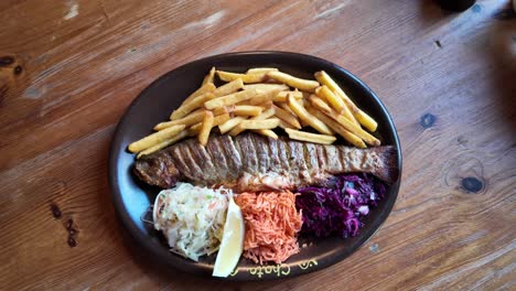 Fresh-Trout-Baked-With-Chips-On-A-Brown-Plate
