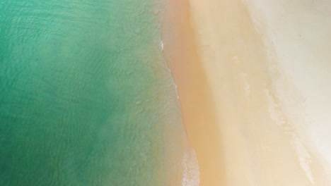 Küste-Und-Ruhige-Wellen-Entlang-Eines-Leeren-Tropischen-Strandes-Mit-Klarem-Blauen-Wasser,-Urlaubsstimmung-Am-Strand,-Luftaufnahme-Von-Oben