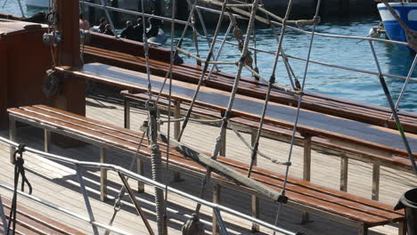 Close-up-on-a-wooden-ship-deck-with-detailed-rigging,-evoking-maritime-heritage-and-the-allure-of-sailing-adventures-on-crystal-waters
