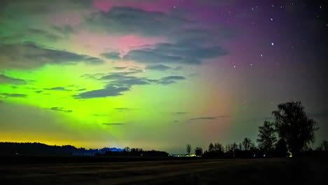 Time-lapse-of-the-vivid-Northern-lights-dancing-above-countryside-farmlands