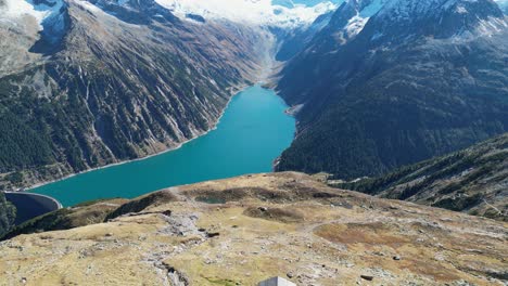 Olpererhutte-Hut-and-Mountain-Lake-Schlegeis-in-Zillertal-Alps,-Austria---Aerial-4k-Reveal