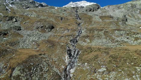 Cascada-Y-Paisaje-Montañoso-En-Los-Alpes-De-Zillertal,-Austria---Pedestal-Aéreo-4k